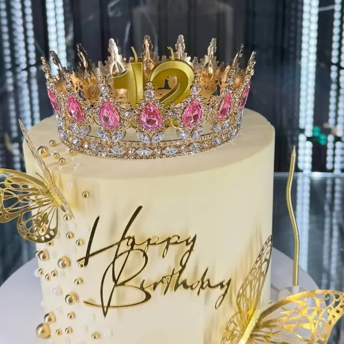 Détail : couronne dorée et papillons sur un gâteau d’anniversaire