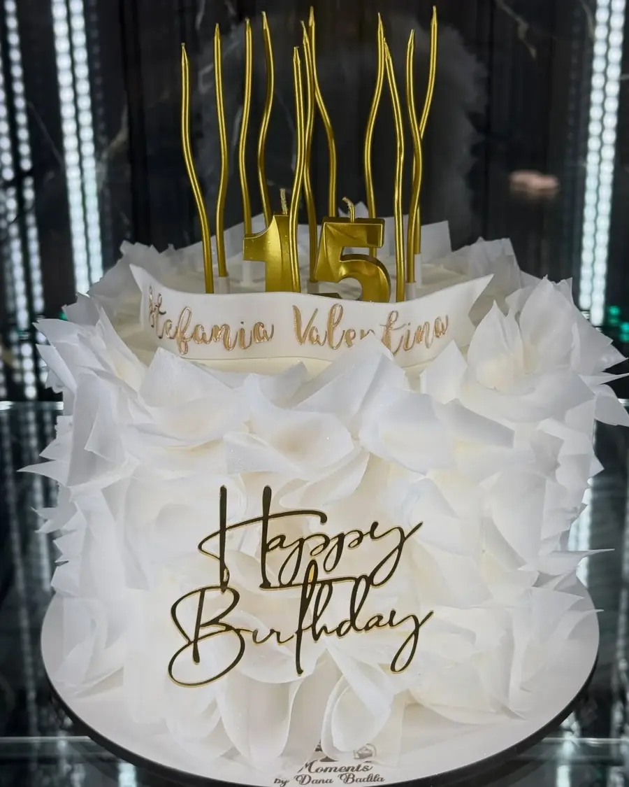 Gâteau d’anniversaire blanc aux plumes en sucre et bougies dorées
