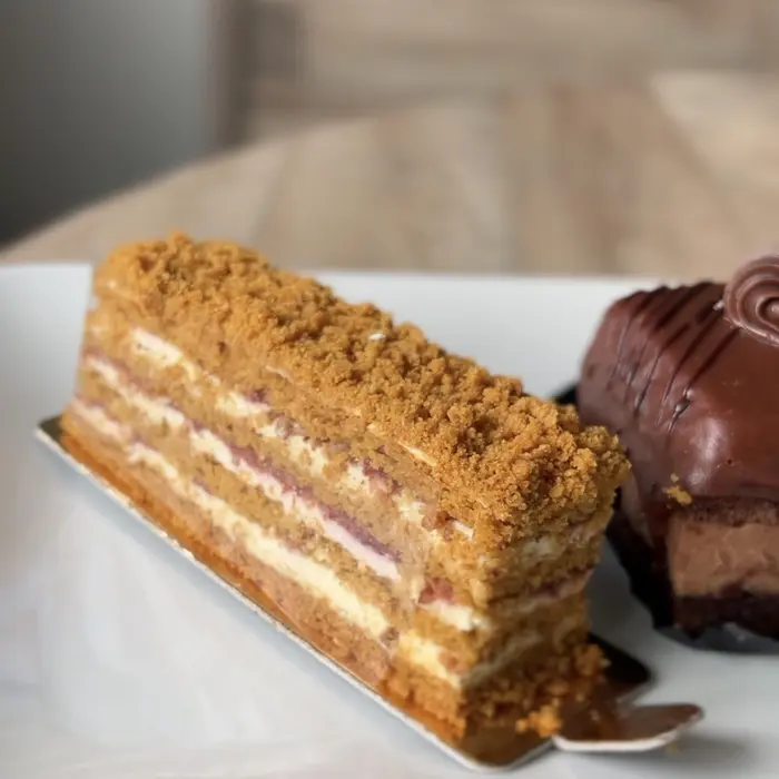 Part de gâteau au miel à étages et entremets au chocolat